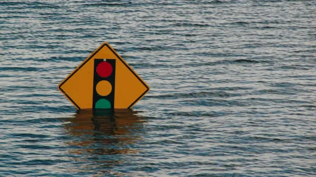 A traffic sign almost completely submerged by water during a flooding event.
