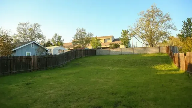 A large empty lot surrounded by a wooden fence