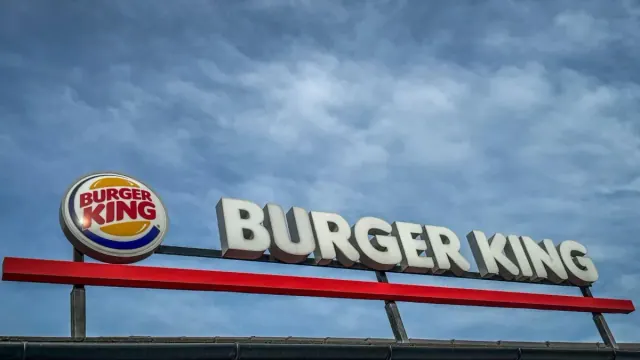 A sign for Burger King next to a Burger King logo.