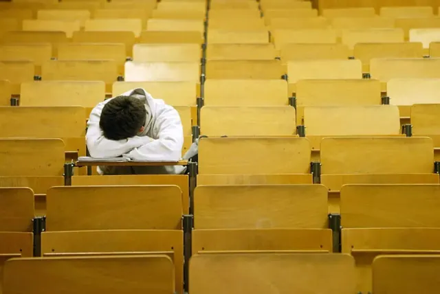 A student naps in a lecture hall at the Freie Universitaet in Berlin, Germany