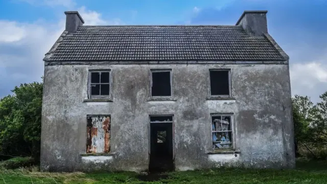 A small gray house in disrepair