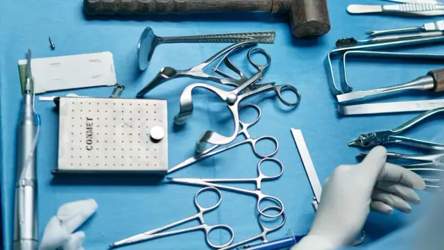 A collection of surgical materials rests on a blue surface