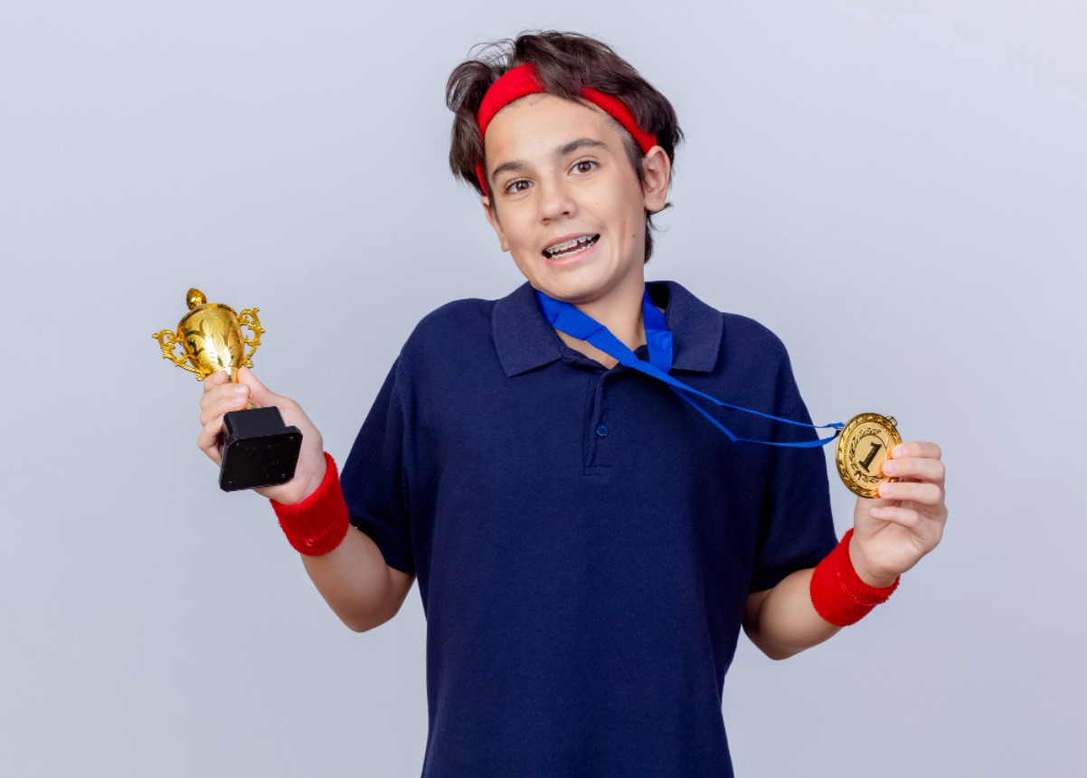 Person holding a trophy and a medal.
