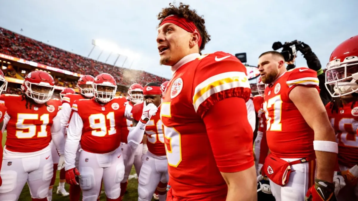 A dynamic photo capturing the Kansas City Chiefs football team in their bright red and white uniforms, standing on the sidelines of a packed stadium