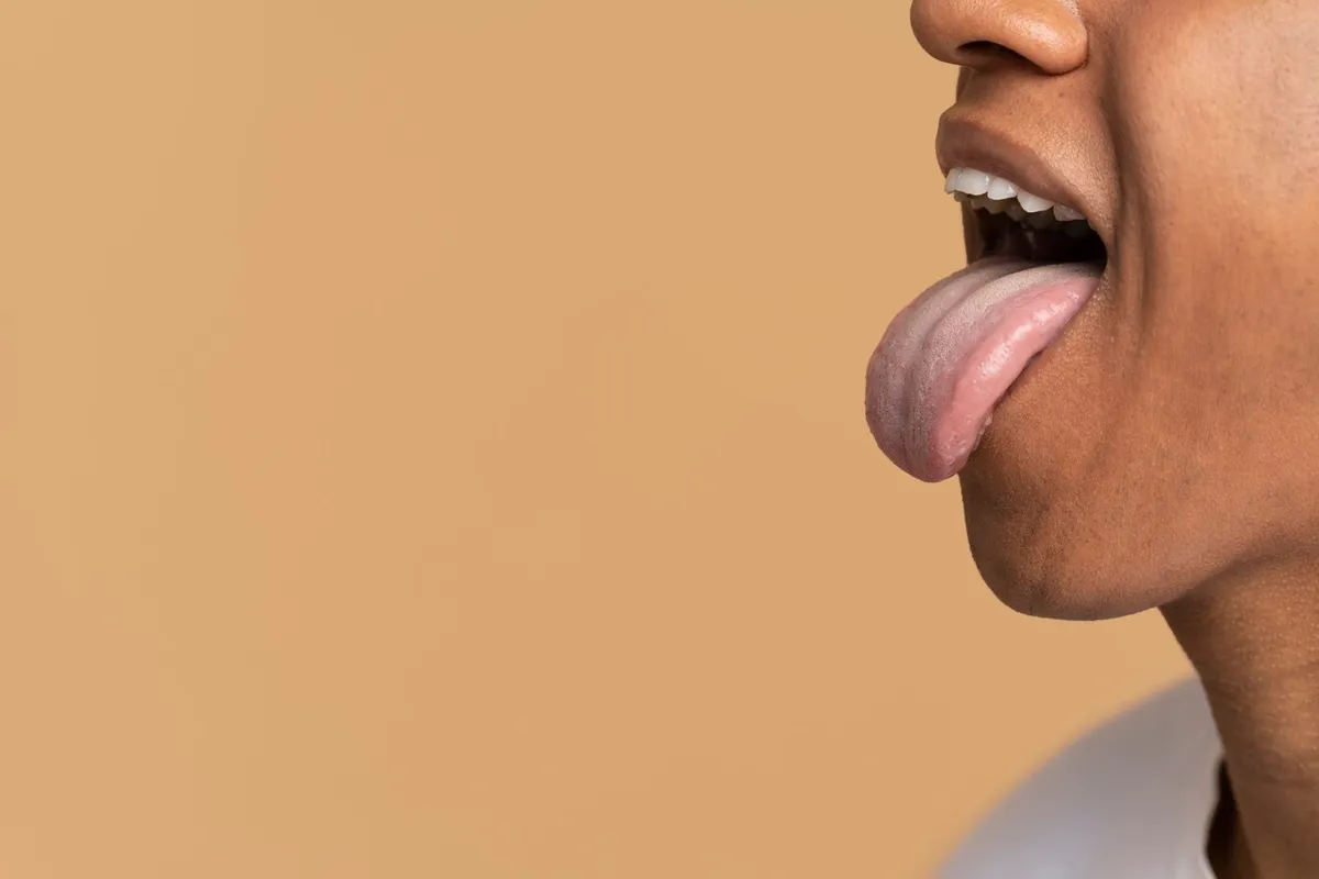 Side view of man sticking his tongue out