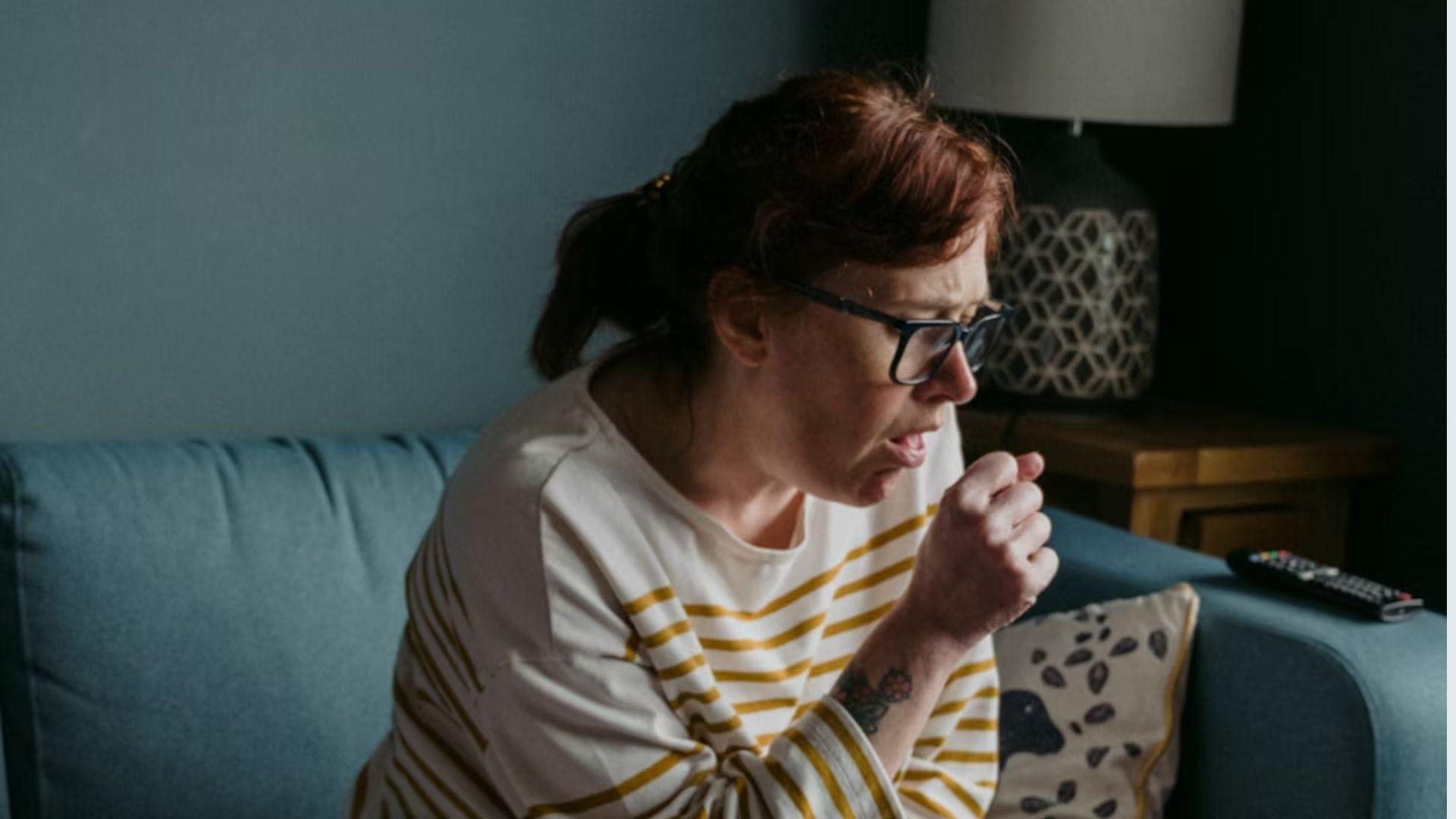 A person coughing into a tissue; illustrative image, not a diagnosed allergic reaction.