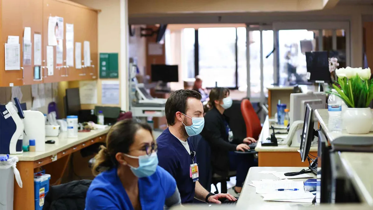 Jesse Cabe (C) and other registered nurses work in the ICU at Providence St. Mary Medical Center on March 11, 2022 in Apple Valley, California