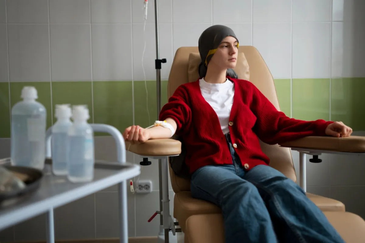 An image of a young woman in a red jacket during a chemotherapy session