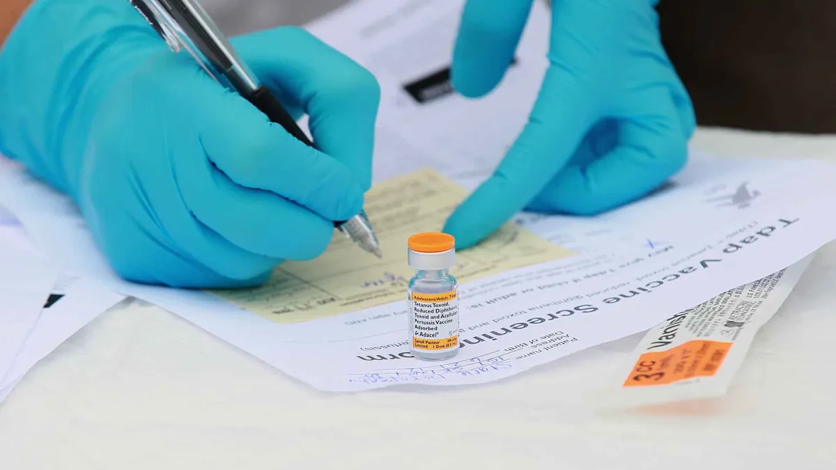 Touro University medical student Shamis Fallah prepares paperwork before adminstering a Tdap vaccination during the Solano County health fair