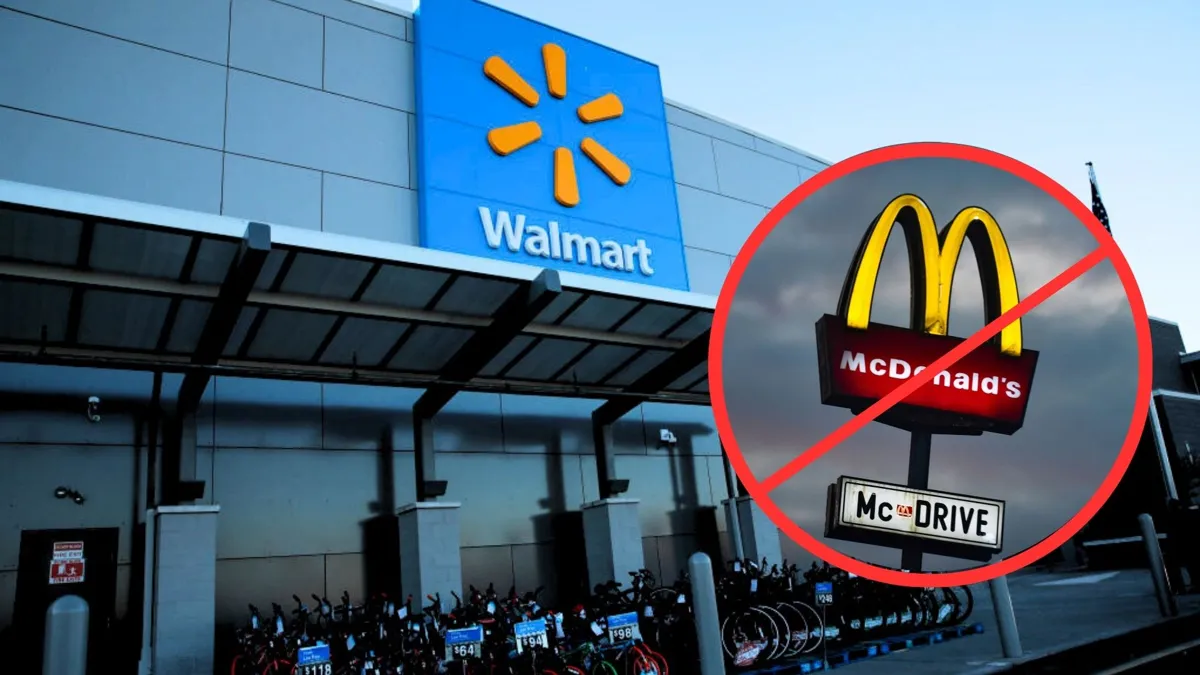 The exterior of a walmart store with a small round image of a McDonalds sign with a red cross over it