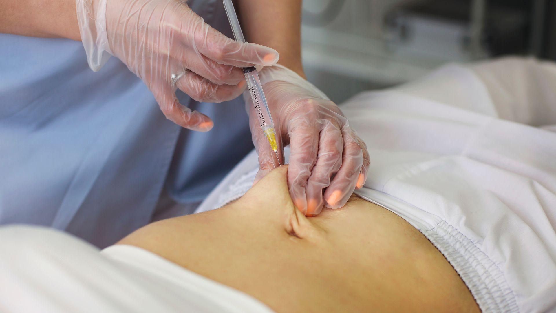 Illustrative stock photograph of a needle used near a person’s back.