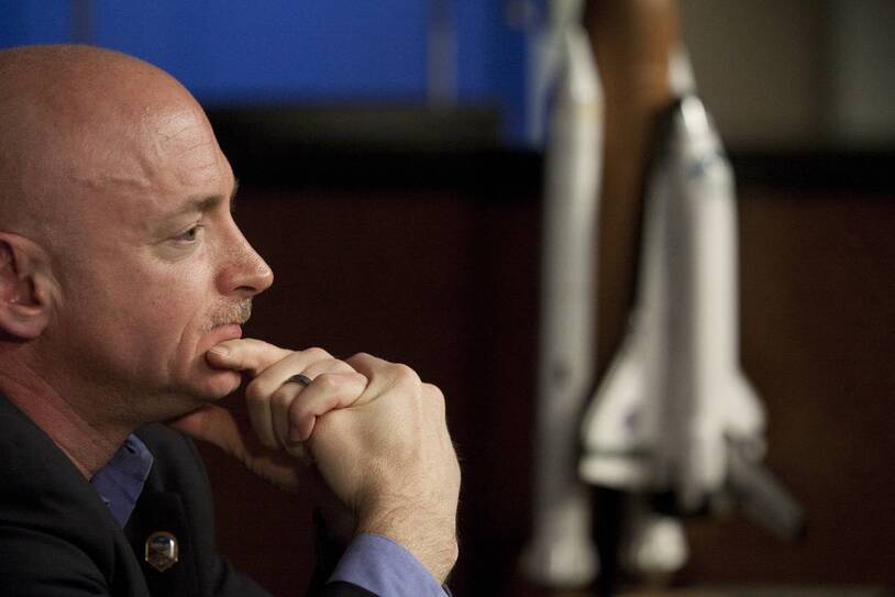A portrait of Scott Kelly resting his chin on his hand
