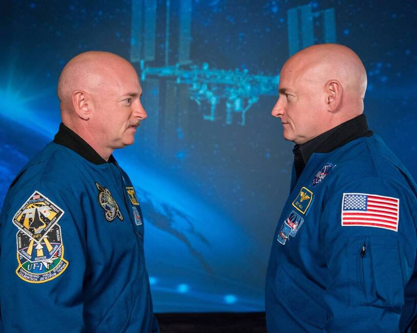 Scott and Mark Kelly facing one another in NASA flight suits
