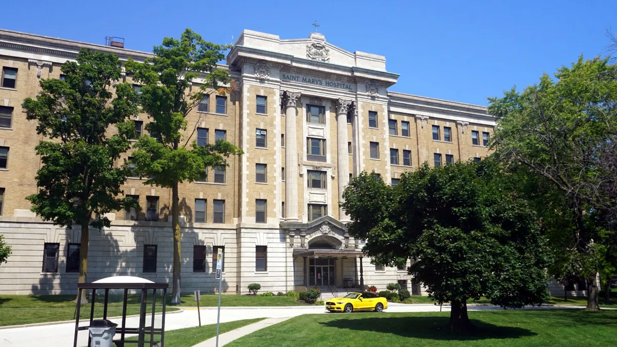St. Mary’s Hospital, an old building, seen with a car out front of it in the daytime in Milwaukee.