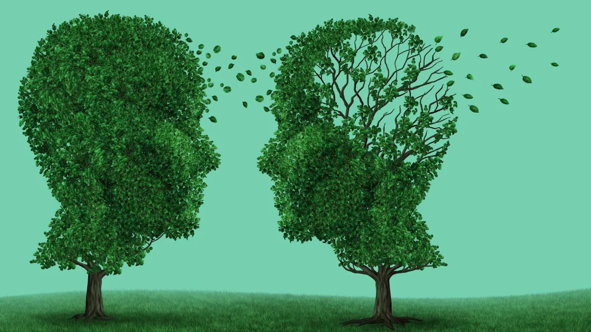 Two trees in the shape of heads, one showing leaves leaving, signifying memory loss
