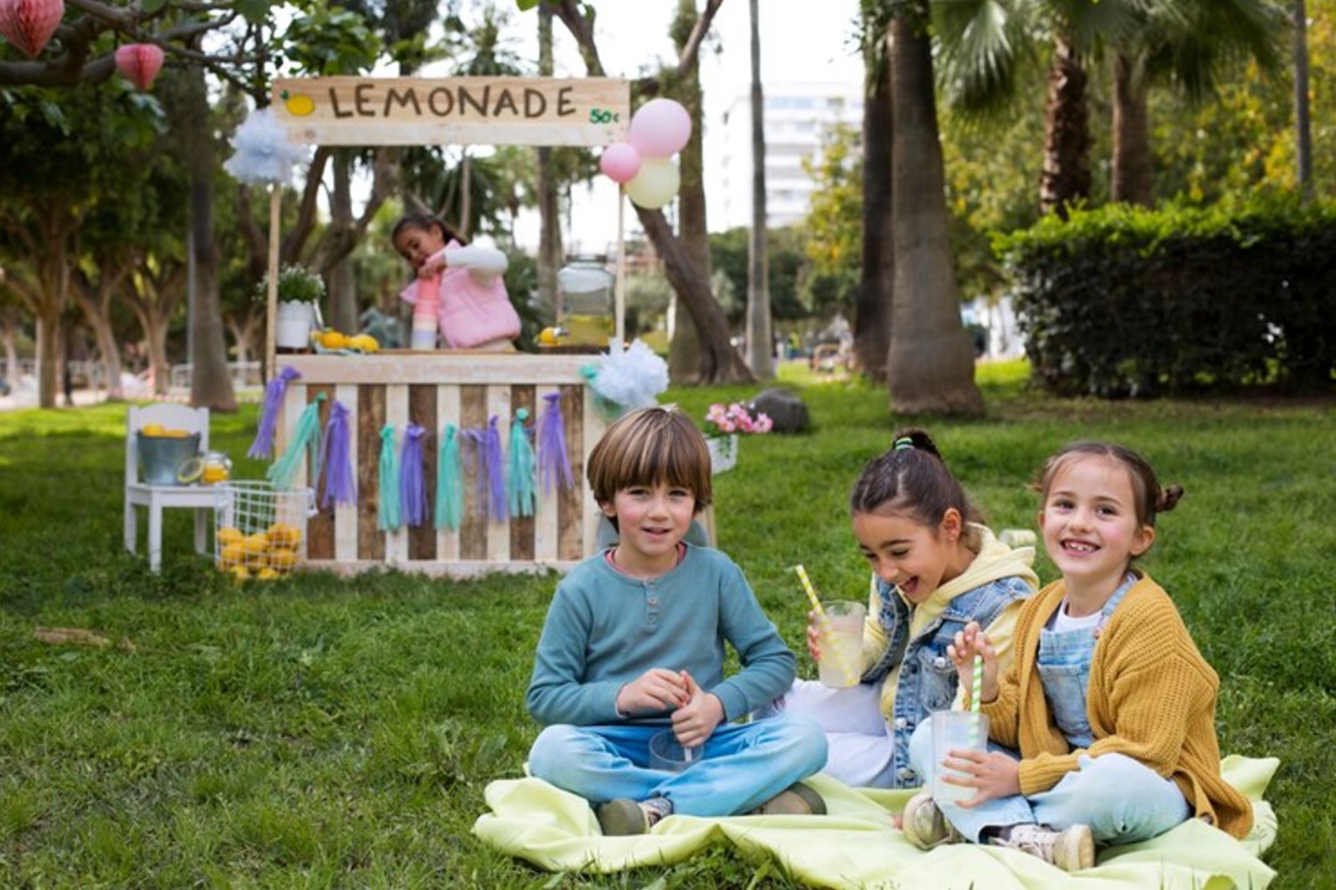 Children having a picnic near a lemonade stand.