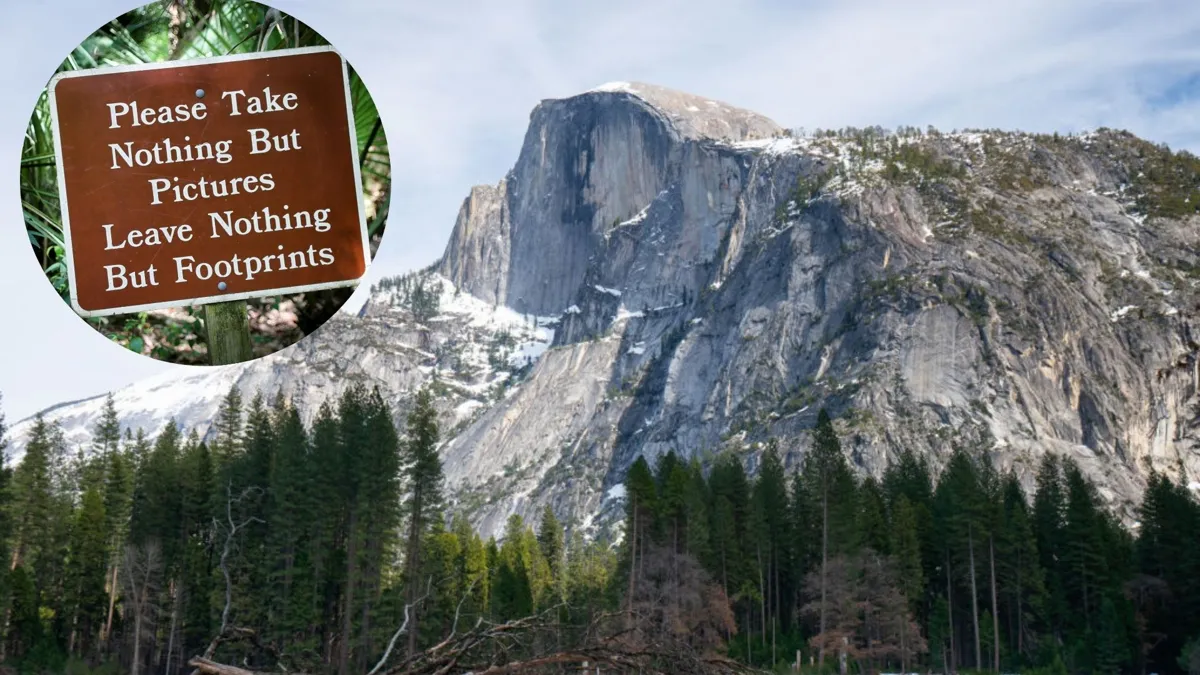A view of Half Dome in Yosemite Valley surrounded by ever green trees and capped with snow. A small ciruclar sign that reads "please take nothing but pictures leave nothing but footprints" is present
