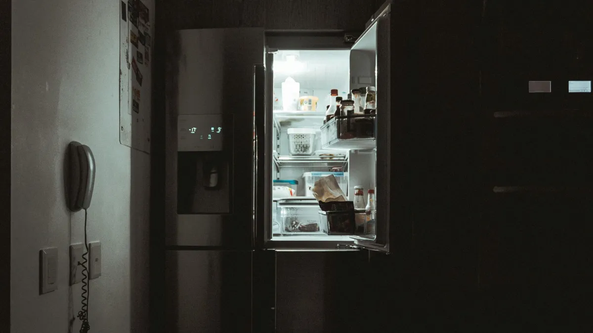 A fridge illuminated at night in a dark kitchen