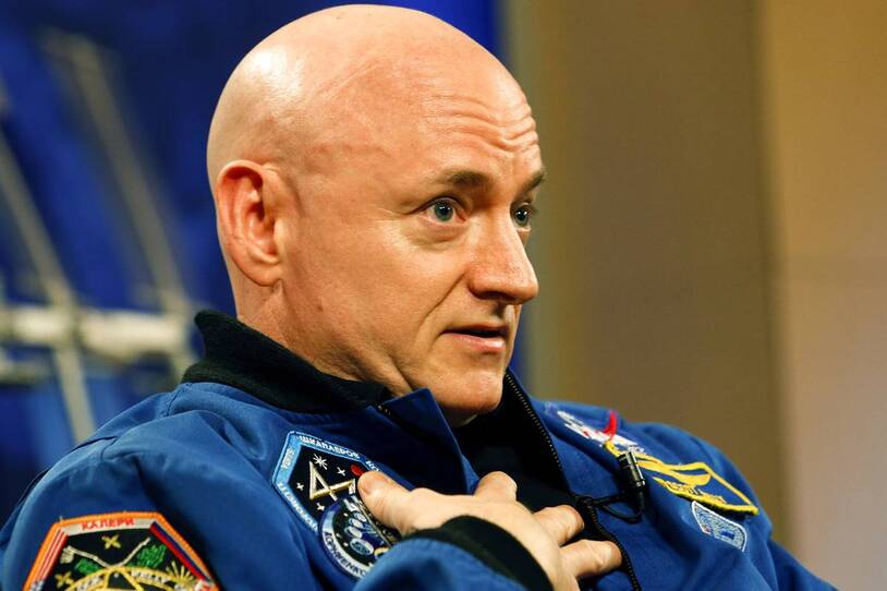 A portrait of an astronaut in a blue flight suit