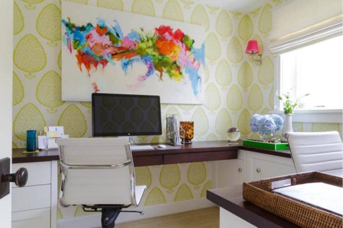 Home office with a patterned wall and framed artwork