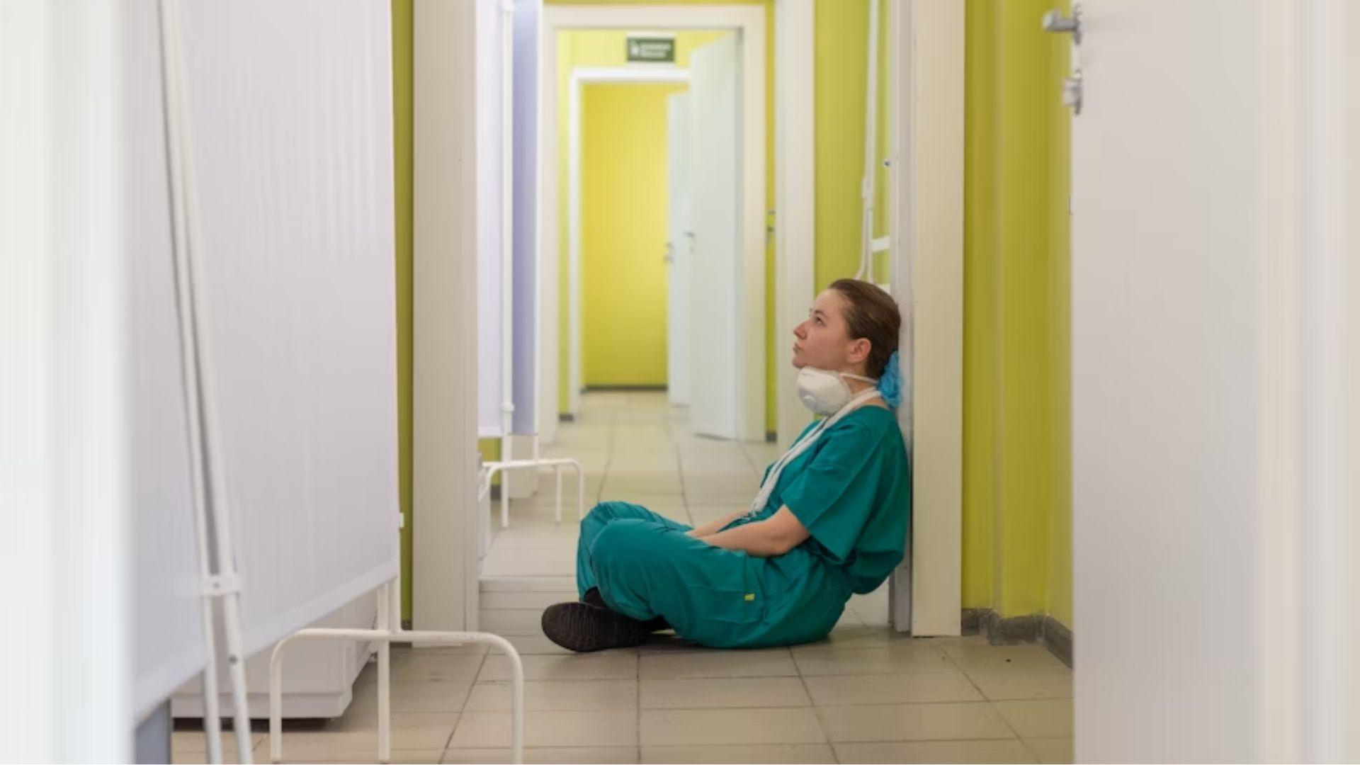 A clinician sitting in a corridor; illustrative archive photograph.