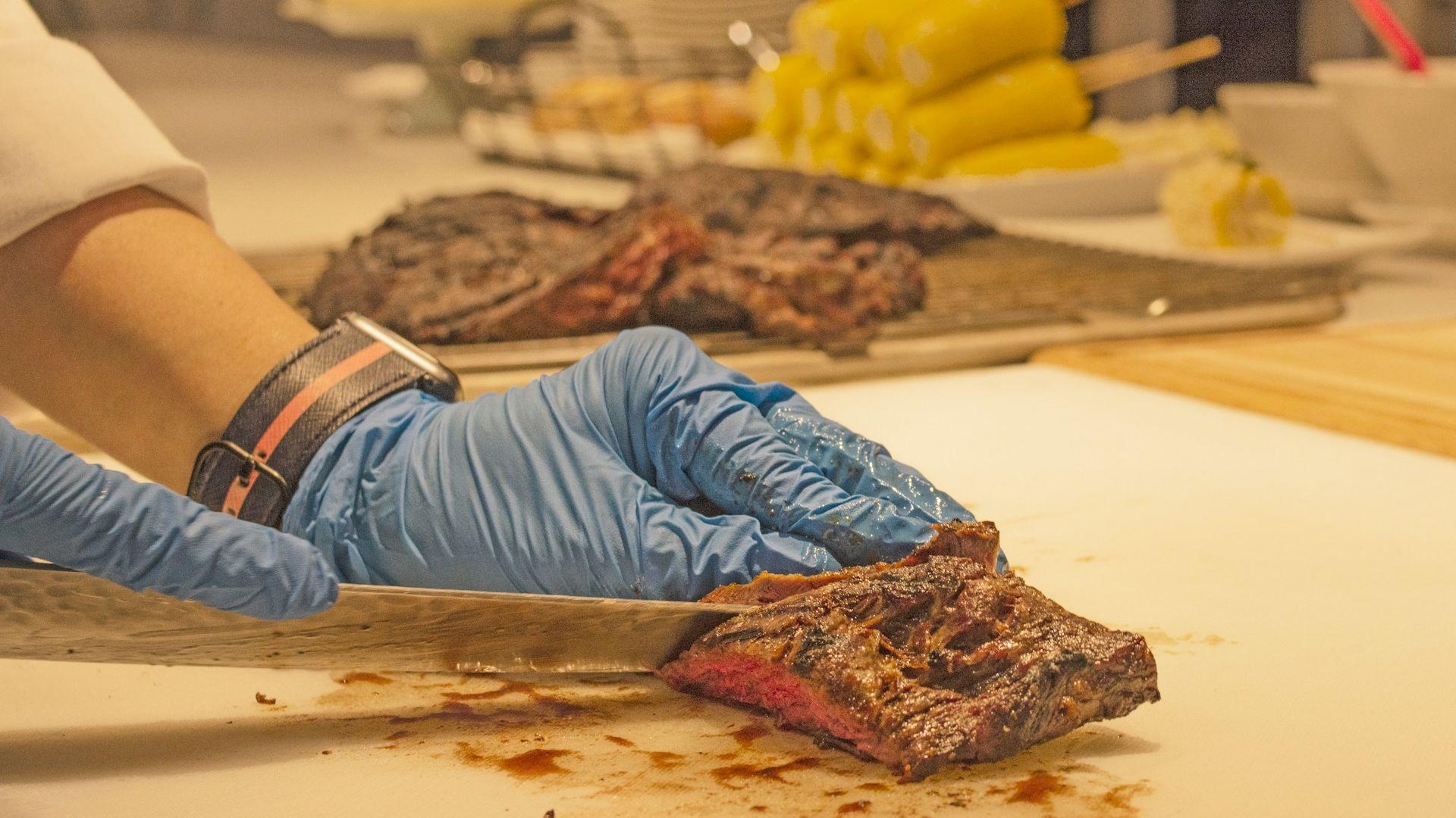 A cook slicing meat; illustrative archive photograph, not a dietary recommendation.