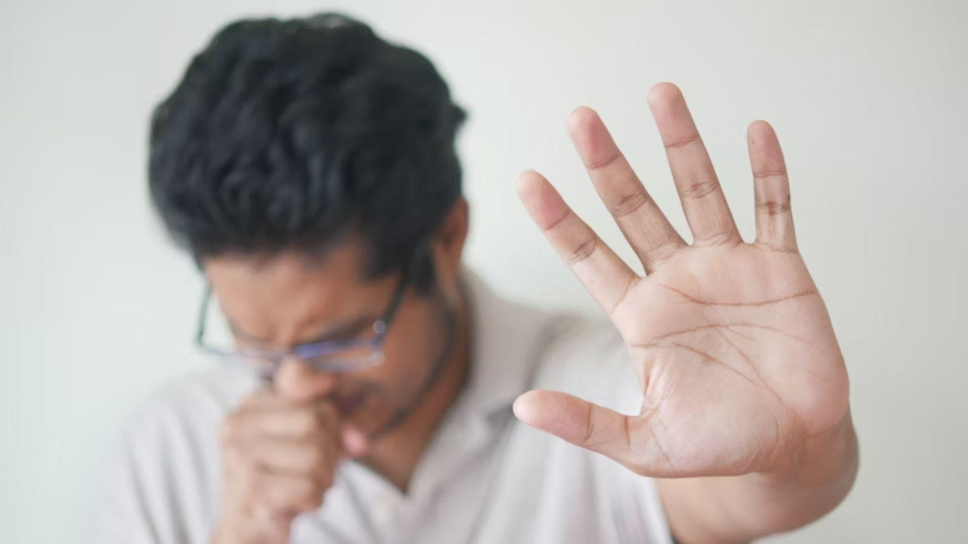 A person raising a hand near their face; illustrative image, not a diagnosed allergic reaction.