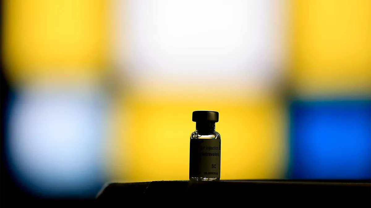 dark silhouette of vaccine bottle