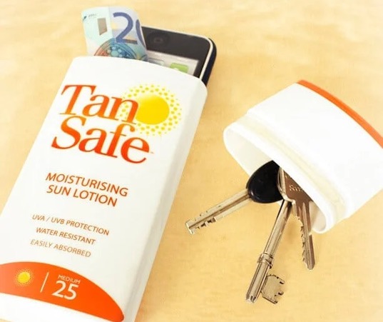 Keys, money and a phone beside a sunscreen-shaped storage container.