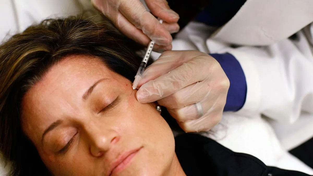 A close-up of a woman receiving a Botox injection from a doctor.