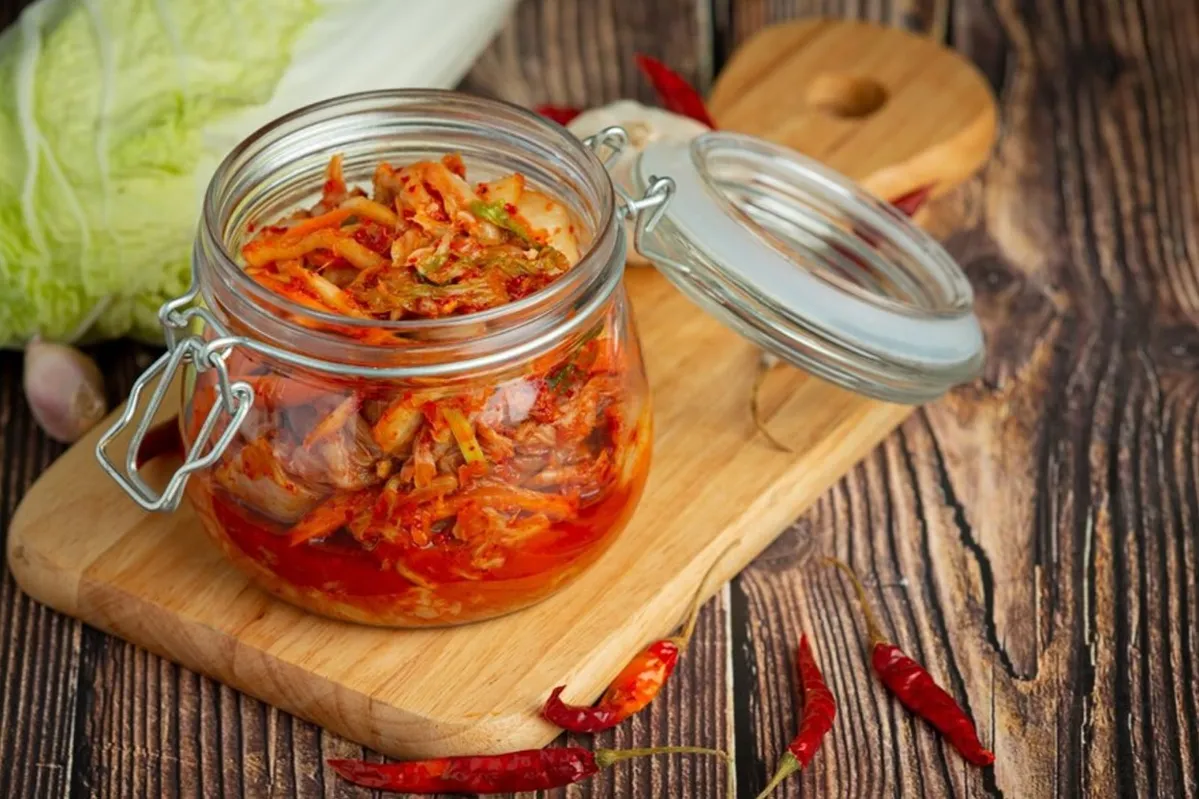 Kimchi in a glass jar on a chopping board