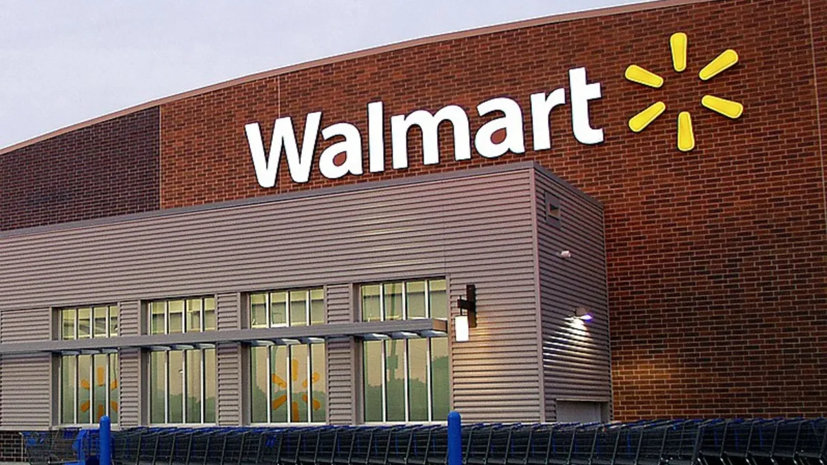 The exterior of a large red store front with the official Walmart logo