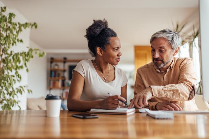Two people reviewing papers at home; illustrative archive photograph.
