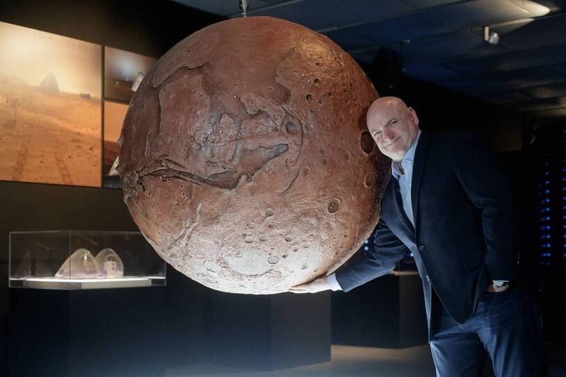 A person looking at a model of Mars