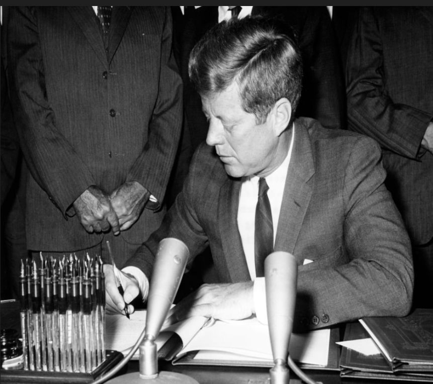 President John F. Kennedy at a microphone