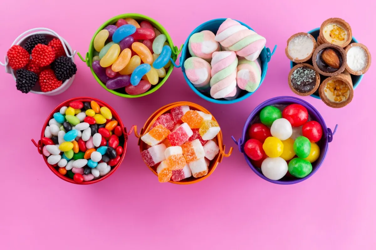 Variety of candies in small bowls on a pink table