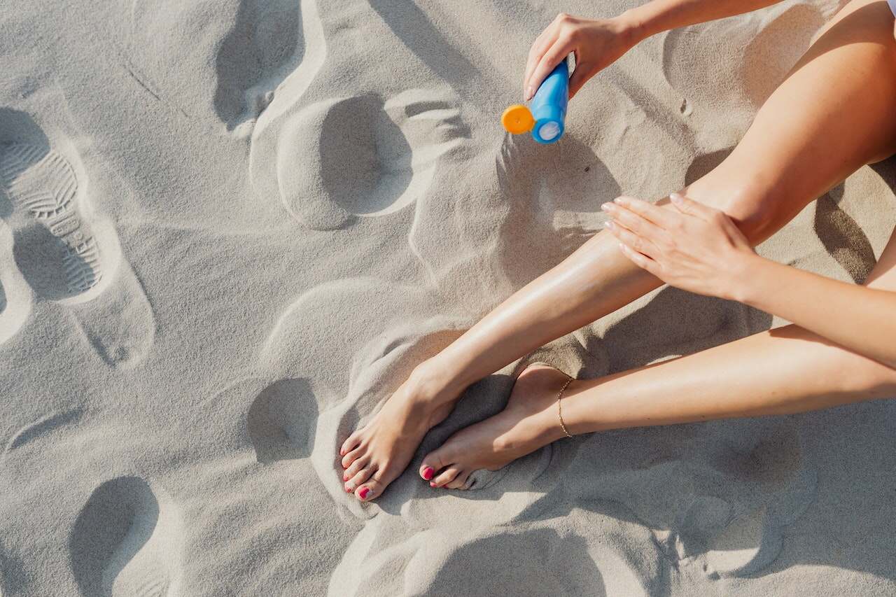 Person applying sunscreen at the beach