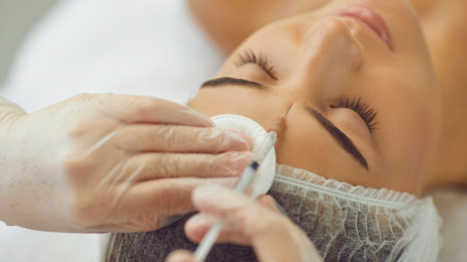 Illustrative stock photograph of a person receiving a facial cosmetic treatment.