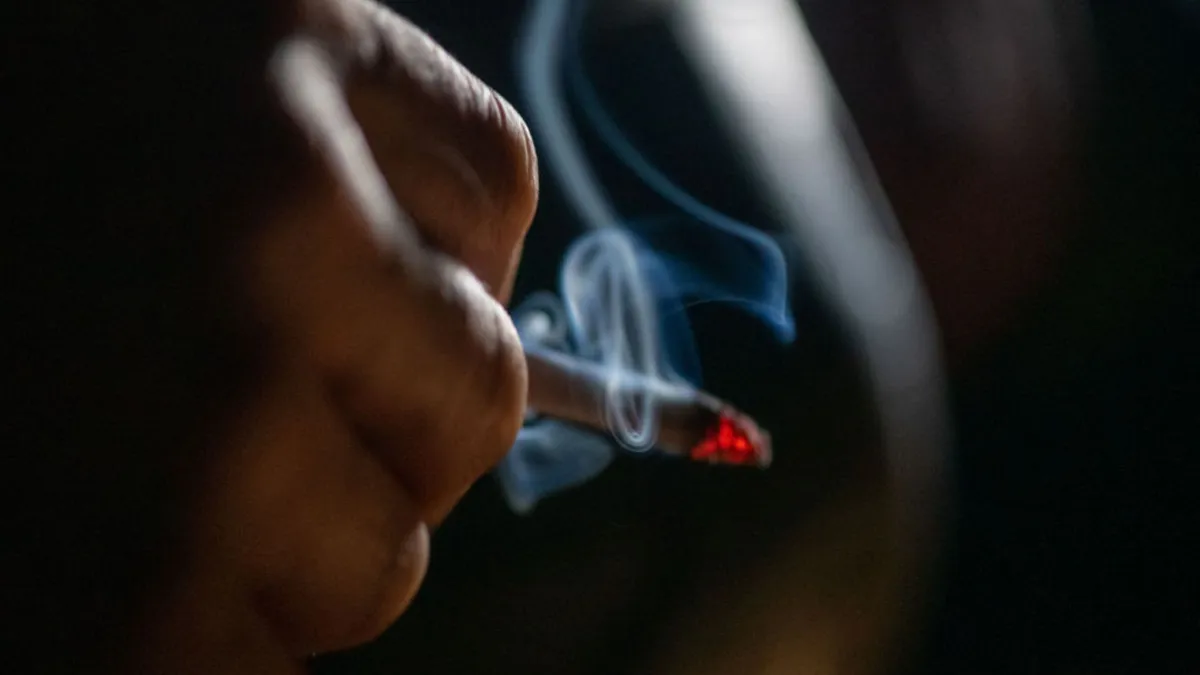 A man holding a lit cigarette