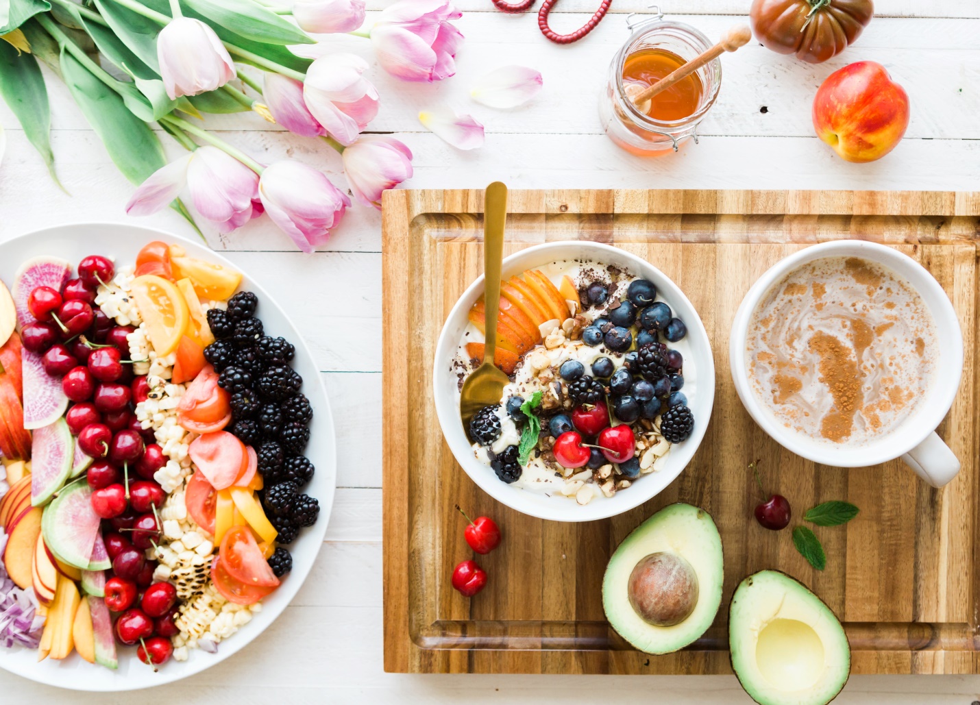 Breakfast bowls, fruit, avocado and drinks on a table