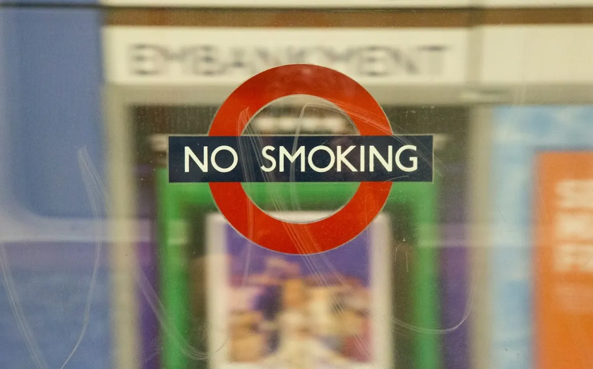 A No Smoking sign on a clear surface at the London Underground