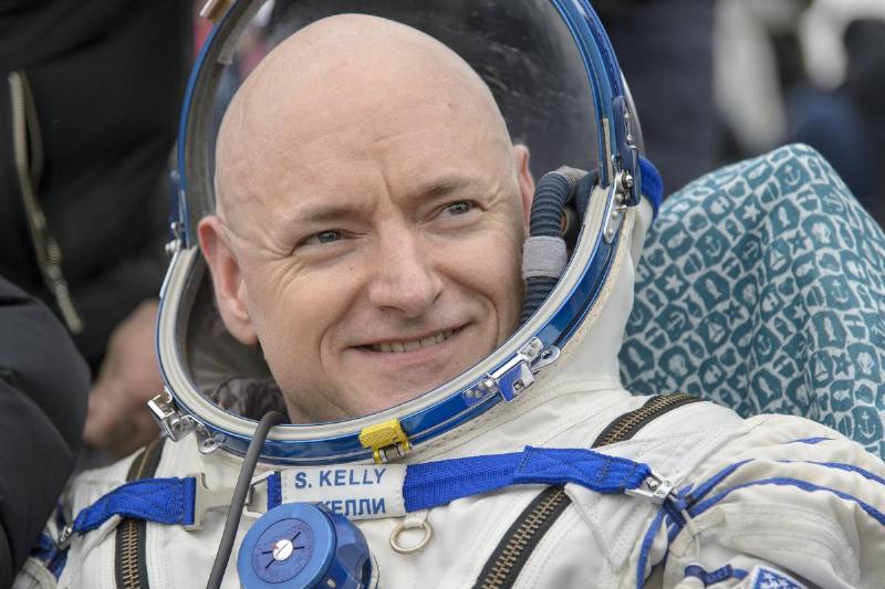 A helmeted astronaut seated in a spacecraft capsule