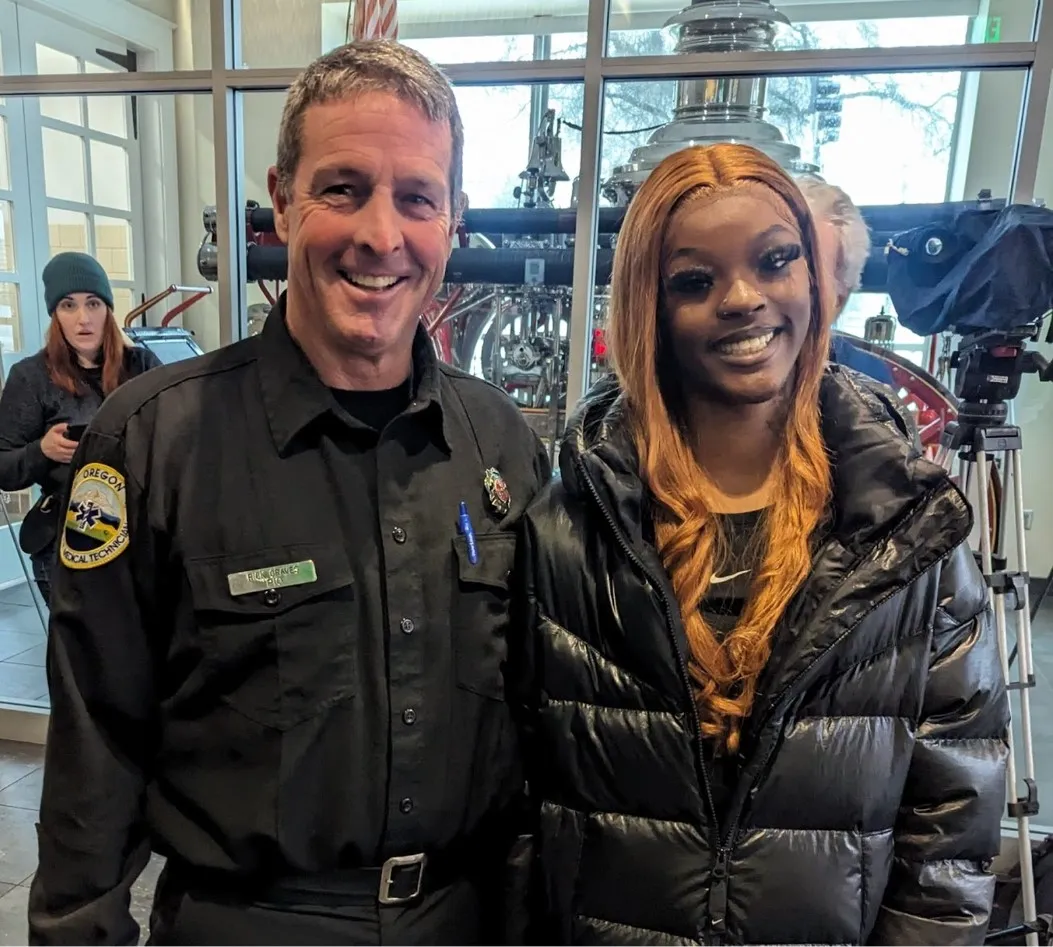 Majiah Washington stands beside an Oregon police officer after giving a speech
