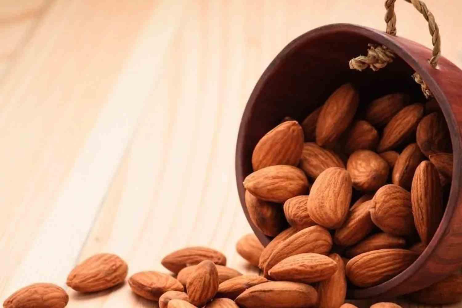 Almonds spilling from a container in an archive photograph.