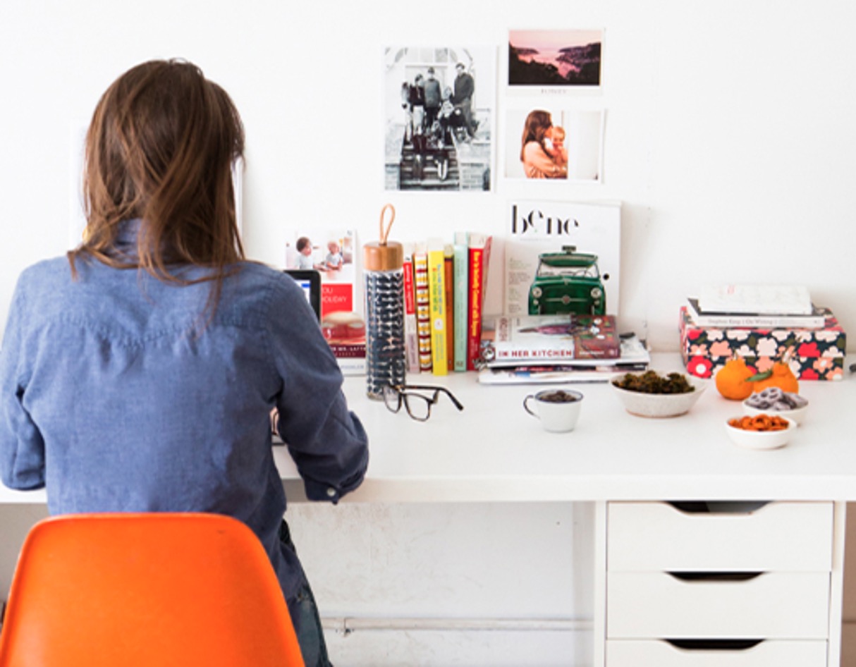 Person working at a desk with papers and a drink