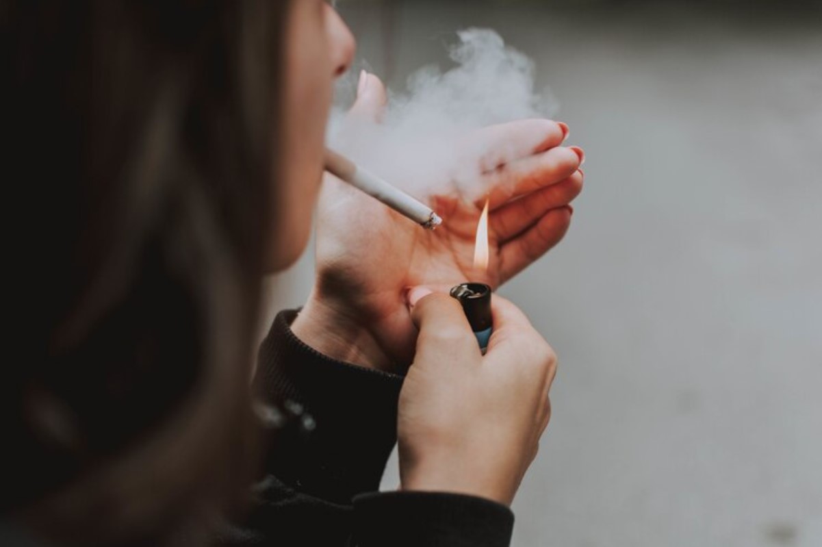 Person lighting a cigarette.