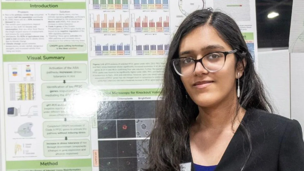 Nandini Rastogi, a young scientist, poses in front of her data on gene editing rice plants