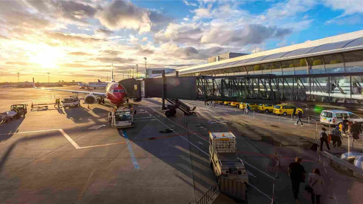 The view of an active airport as the sun sets in the sky.