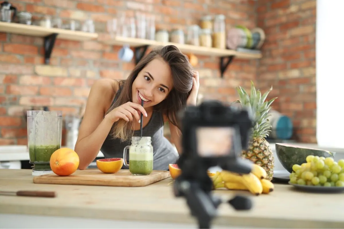 Wellness influencer recording a video for social media in her kitchen