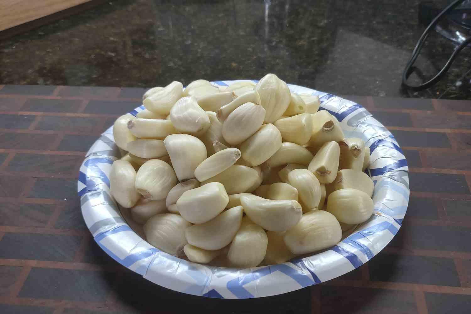 Peeled garlic cloves on a plate in an archive photograph.